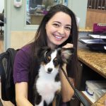 dog sitting in staff member's lap