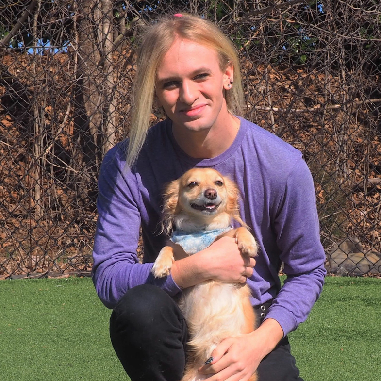 Blond man holding small dog