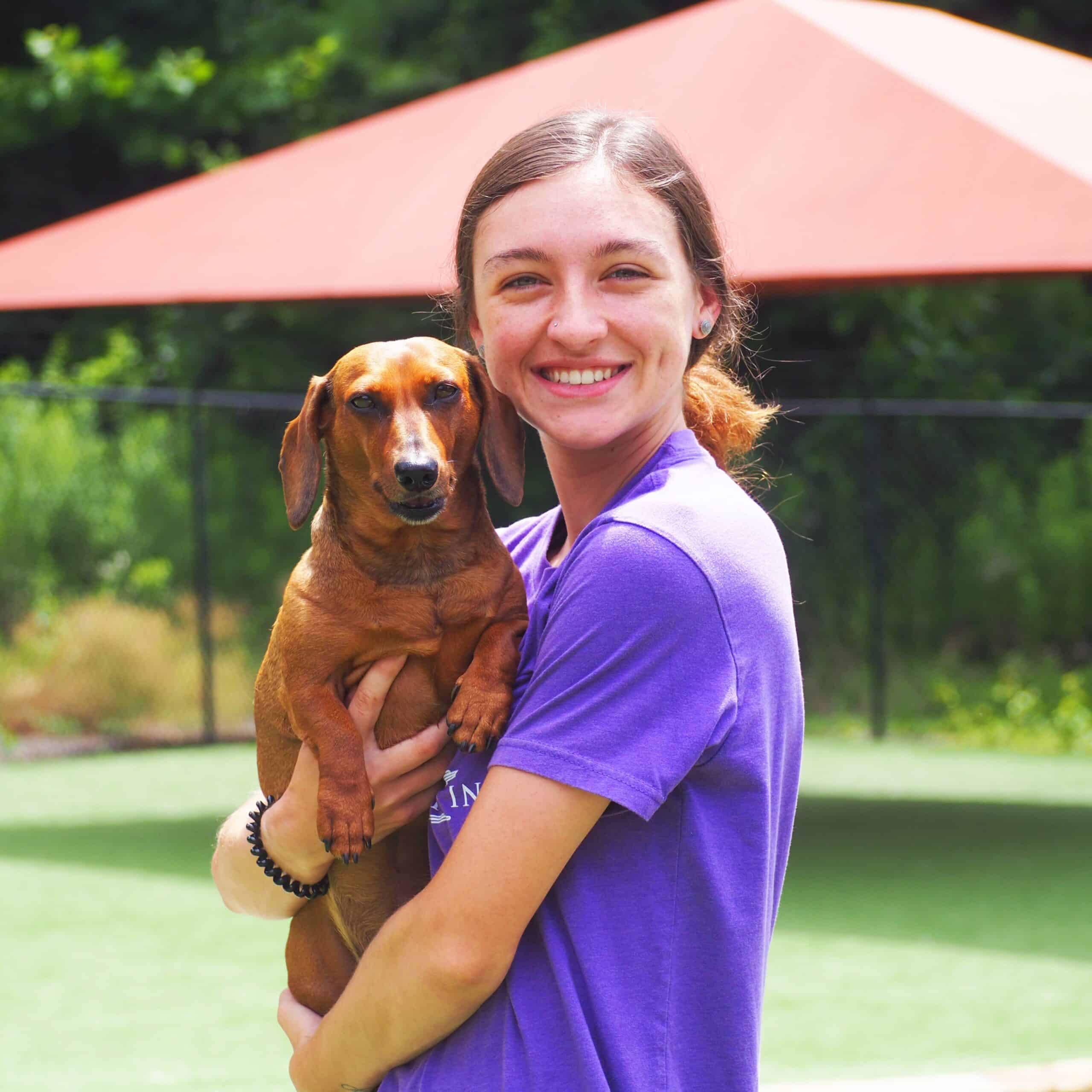 Staff member posing with a dog.