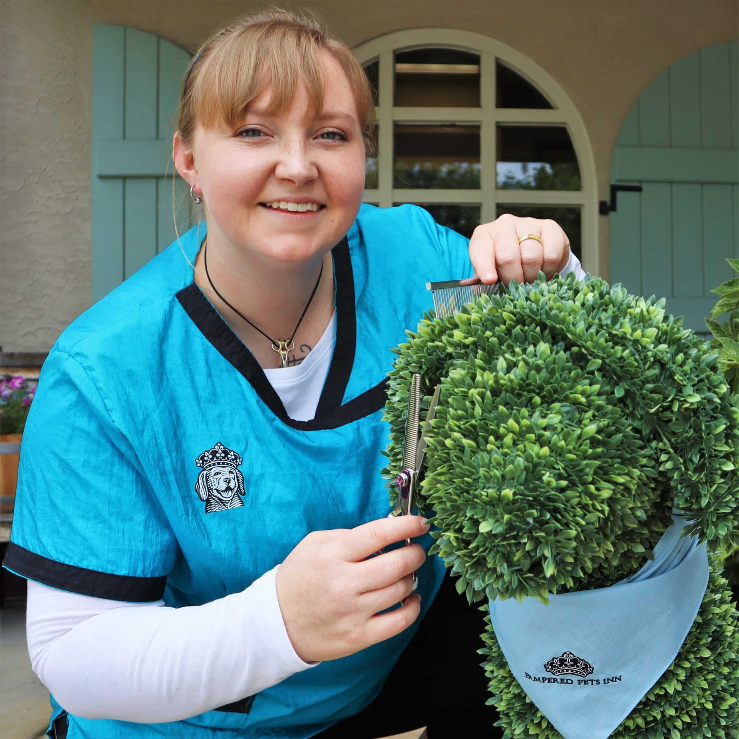 Dog Groomer posing with shrub