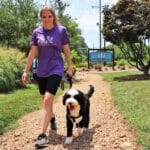 Dog trainer walking a dog over to the training center