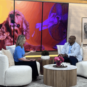 Two people sitting on couches in a news room 