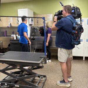 a cameraman and two people standing in front of a tub.