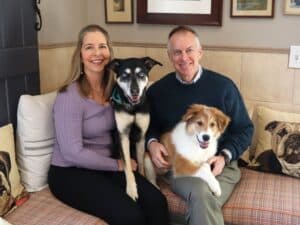 The owners of Pampered Pets Inn sitting with their two dogs Macy and new puppy Finley